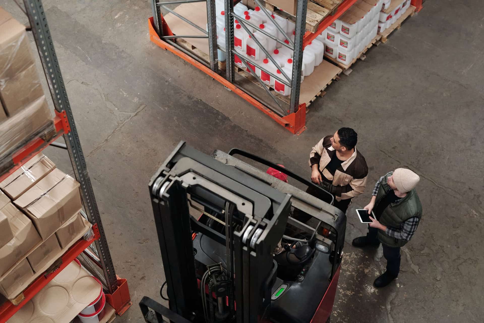 שני עובדים בוחנים מלאי במחסן לוגיסטי לצד מלגזה